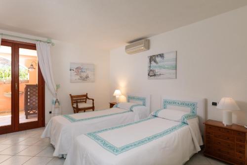 Dos camas en una habitación blanca con ventana. en Casa Acqua e Pietra by Wonderful Italy, en Casa Tamponi