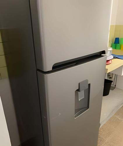 a refrigerator in a kitchen next to a desk at Cómodo departamento en el corazón de Cancún in Cancún
