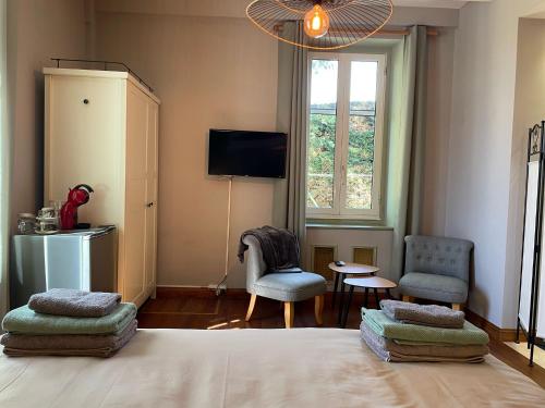 a bedroom with a bed with two chairs and a window at Favau in Villeneuve-sur-Lot