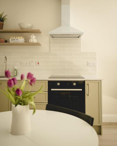 a kitchen with a stove and a vase of flowers at The Old Schoolhouse - The Courtyard in Donegal