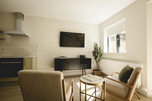 a living room with two chairs and a tv at The Old Schoolhouse - The Courtyard in Donegal