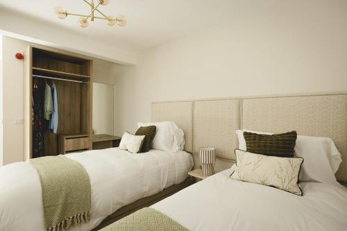 a bedroom with two beds and a headboard at The Old Schoolhouse - The Courtyard in Donegal