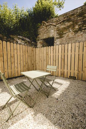 a table and two chairs in front of a fence at The Old Schoolhouse - The Courtyard in Donegal