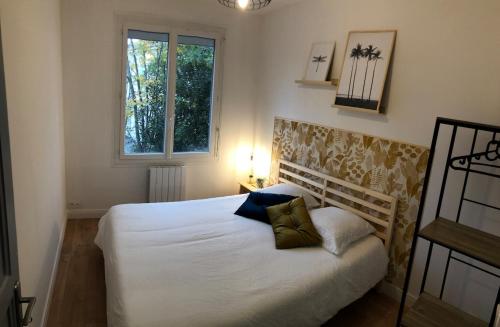 une chambre avec un lit blanc et une fenêtre dans l'établissement Appartement 3 chambres - grande terrasse, à Saint-Nazaire