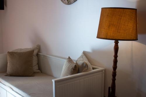 a lamp sitting next to a bed with pillows at Agriturismo Valpagliaro in Formignana