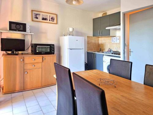 une cuisine et une salle à manger avec une table et un réfrigérateur dans l'établissement T3 Bandol, à Bandol