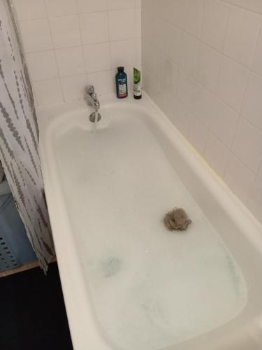 une salle de bain avec une baignoire avec un sol sale dans l'établissement viva normandie, à Sainte-Gauburge-Sainte-Colombe