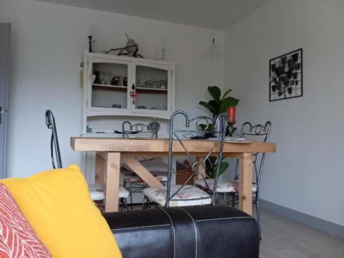 un salon avec une table et une chaise dans l'établissement viva normandie, à Sainte-Gauburge-Sainte-Colombe