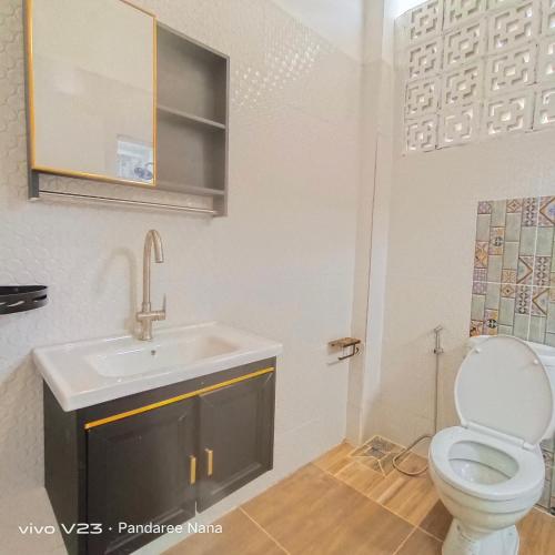 a bathroom with a toilet and a sink at MaHaNa Hostel Pattaya in Jomtien Beach