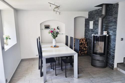 une salle à manger avec une table blanche et une cheminée dans l'établissement Le Beau-Mont Triplex moderne lit King Size proche Geneve, à Présilly