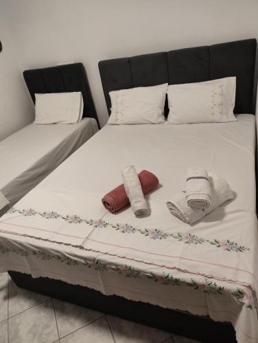 a bed with two pillows and towels on it at Anna's Garden House in Limenas