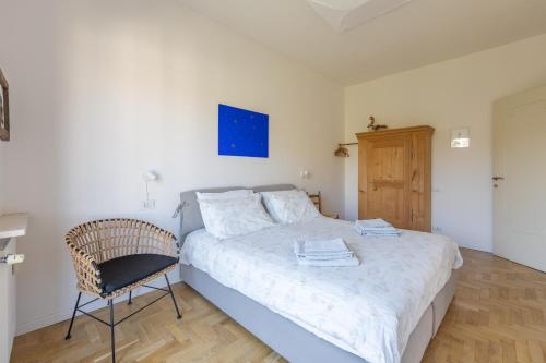 a small bedroom with a bed and a chair at Blue Dream in Ispra