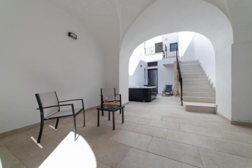 une chambre avec deux chaises et un escalier dans l'établissement Nara Apartments 2 - Private Jacuzzi, à Tricase