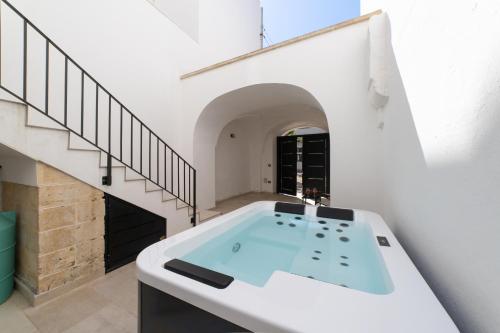 une salle de bain avec une baignoire au milieu d'un escalier dans l'établissement Nara Apartments 2 - Private Jacuzzi, à Tricase