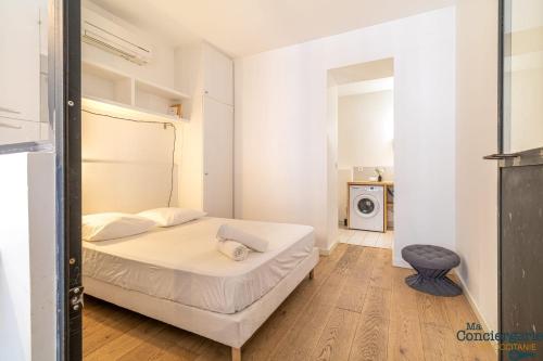une chambre blanche avec un lit et une chaise dans l'établissement DV1 Le gris Chiné - Metro - Gare centre ville, à Toulouse