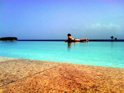 a person laying in the water on a beach at Blue Horizon Boutique Resort in Vieques