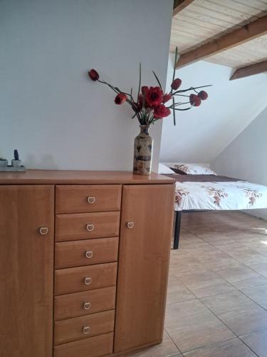 a vase with flowers on a dresser in a room at bizon in Sadowne