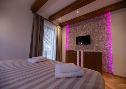 a bedroom with a bed with purple lights on the wall at Casa Danciu in Fînaţe