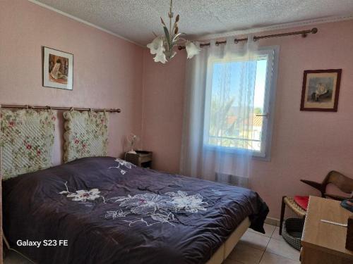 une chambre avec un lit avec une couette bleue et une fenêtre dans l'établissement Villa Florentine Fréjus, à Fréjus