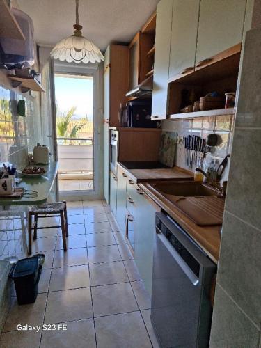 une cuisine avec un évier, une table et une fenêtre dans l'établissement Villa Florentine Fréjus, à Fréjus