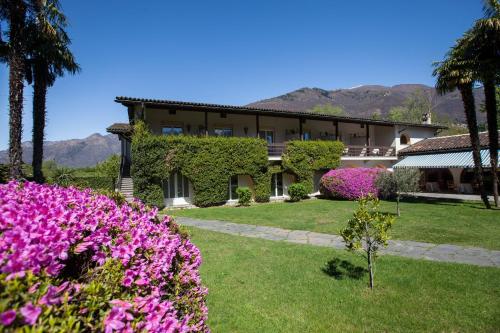 a house with purple flowers in front of it at Villa Favorita - Parkhotel Delta in Ascona