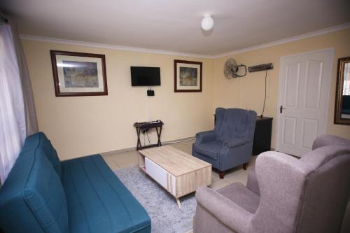a living room with two chairs and a blue couch at Twenty 4 Hr Self-Catering Accomodation in Mthatha