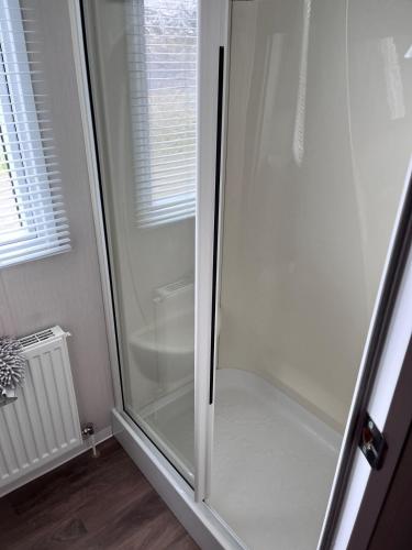 a shower with a glass door in a bathroom at Molly's Haven in Milford on Sea