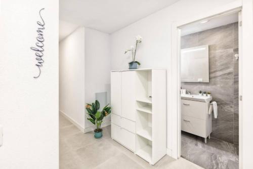 Un baño blanco con lavabo y espejo. en Ocean Blue Dream, en Breña Baja