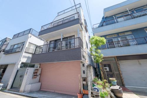 an apartment building with a garage and a balcony at Akabane Nishi Masuda House in Tokyo