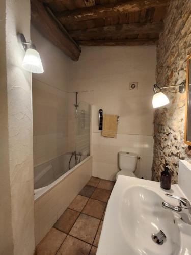 a bathroom with a tub and a sink and a toilet at Le Clos Sainte Marie - Caune in Cenne-Monestiès
