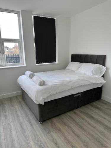 a large bed in a room with a window at Train Station Aparthotel - Free Wifi, Free Parking in Scunthorpe