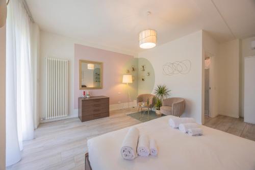 a bedroom with a white bed with towels on it at Appartamenti Villa Andrea in Garda