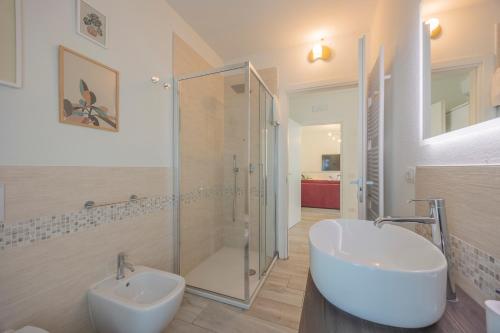 a bathroom with a glass shower and a sink at Appartamenti Villa Andrea in Garda