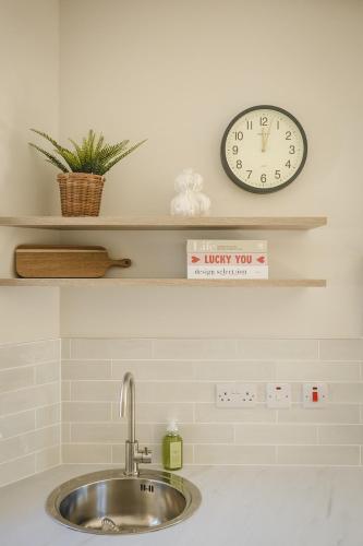 a clock on a shelf above a sink at The Old Schoolhouse - Teacher's Quarters in Donegal