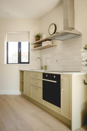 a kitchen with a sink and a clock on the wall at The Old Schoolhouse - Teacher's Quarters in Donegal