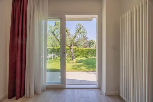 an open glass door with a view of a yard at Appartamenti Villa Andrea in Garda