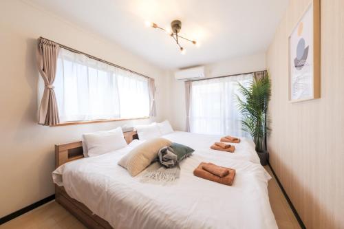 a bedroom with a large bed with towels on it at Akabane Nishi Masuda House in Tokyo