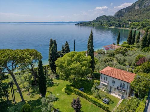 an aerial view of a house on the shore of a lake at Appartamenti Villa Andrea in Garda