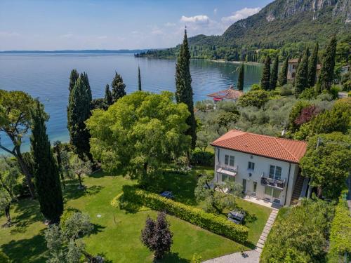 an aerial view of a house on the shore of a lake at Appartamenti Villa Andrea in Garda