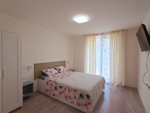 a bedroom with a bed and a large window at ATEA PERLA apartments in Kavarna