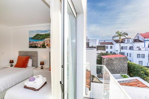 una camera da letto con balcone, letto e vista di GuestReady - Passal Guesthouse a Ponta Delgada