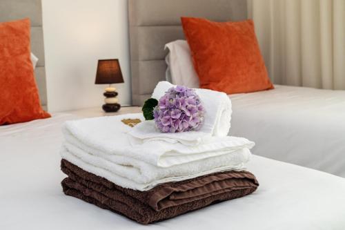 un mucchio di asciugamani e un fiore su un letto di GuestReady - Passal Guesthouse a Ponta Delgada