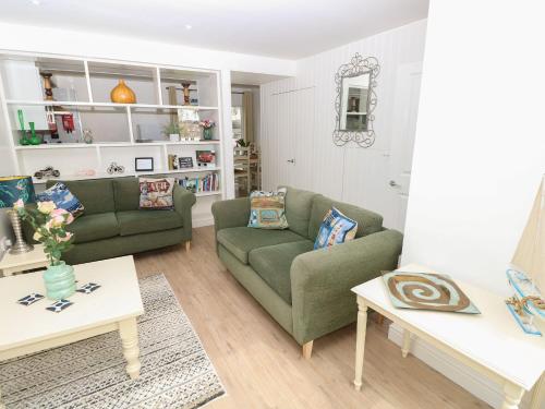 a living room with two green couches and a table at Delaware M3 in Yarmouth