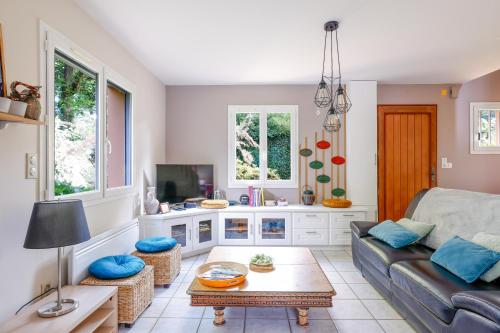 a living room with a couch and a table at Maison au milieu d'un parc arboré in Le Faouët