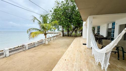 a porch of a house with a hammock on the beach at Cabaña Costa de Oro in San Antero