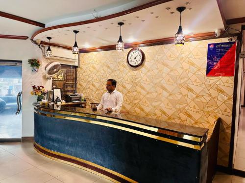 a man standing at a bar in a restaurant at Fiesta Inn Hotel & Resorts Multan in Multan
