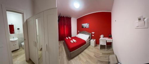 1 dormitorio rojo con 1 cama y baño en Alì Babà Rooms, en La Spezia