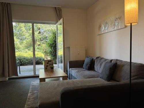 a living room with a couch and a large window at Geräumige Wohnung in Altenau mit Terrasse in Lissendorf
