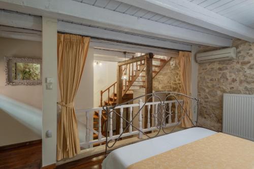 a bedroom with a bed and a staircase at Arhontiko Arhanes Suites in Archanes