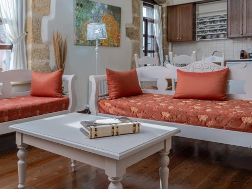 a living room with two couches and a coffee table at Arhontiko Arhanes Suites in Archanes